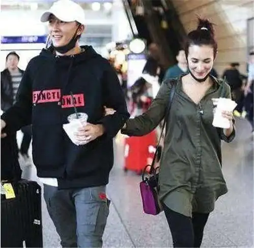 韩庚现身机场秀恩爱轻挽手臂小鸟依人羡煞旁人